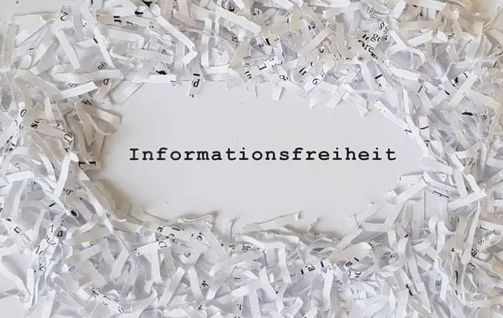 Papierstreifen aus Aktenvernichter mit Schriftzug ‚Informationsfreiheit