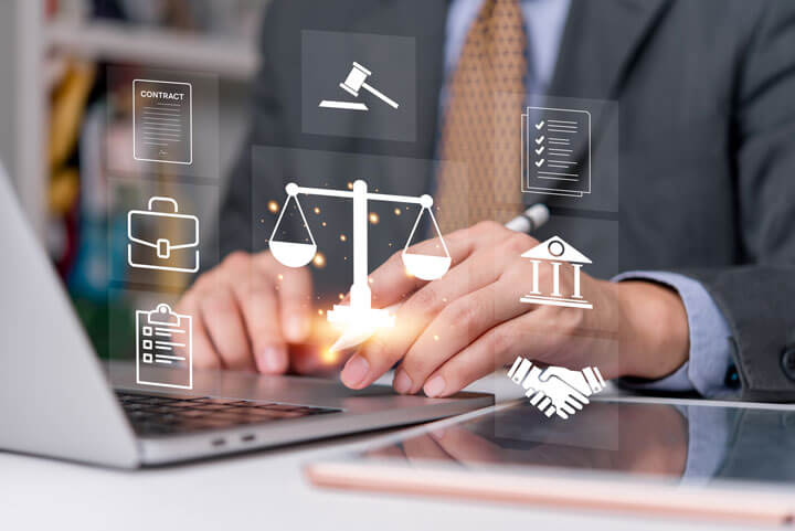 Geschäftsmann arbeitet am Laptop mit eingeblendeten Rechtssymbolen